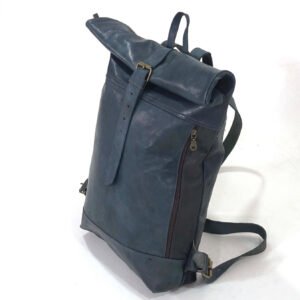 A teal blue rolltop backpack with one strap